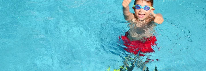 Kind mit Taucherbrille und Flossen im Pool
